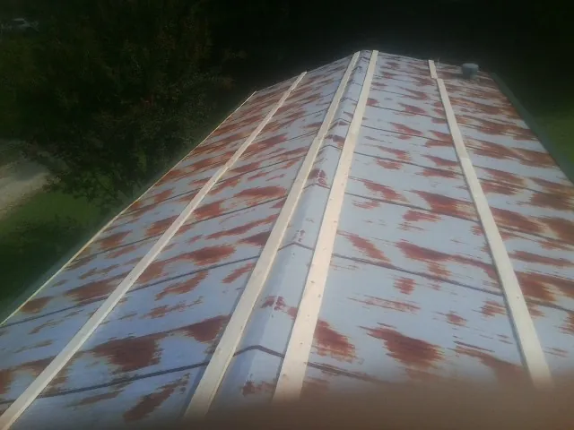 Rusted metal roof panels with new wood purlins before replacement — Storm Damage Roof Repair in Hampstead by Roofing Brothers